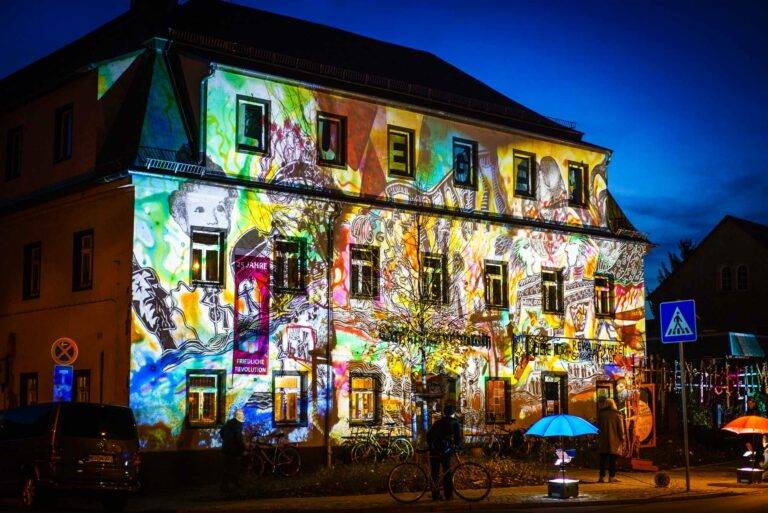 Lügenmuseum Radebeul - während der Klassenfahrt nach Dresden besucht die Schulklasse das einzigartige Lügenmusem. Auf dem Bild sehen wir das kunterbunte Gebäude bei Nacht mit beleuchteter Fassade.